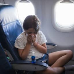 Young girl with a runny nose on a plane.